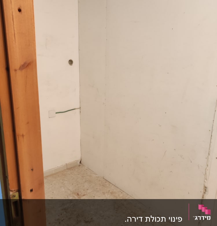 קיר לבן עם חור קטן ורצפה מלוכלכת